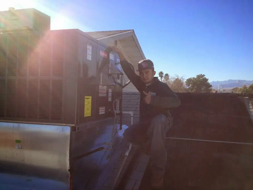 HVAC technician performing Boiler Repair on a rooftop unit in Tisbury